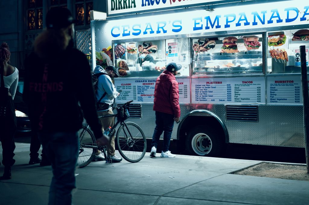 Vibrant urban scene of people enjoying a food truck at night in New York City.