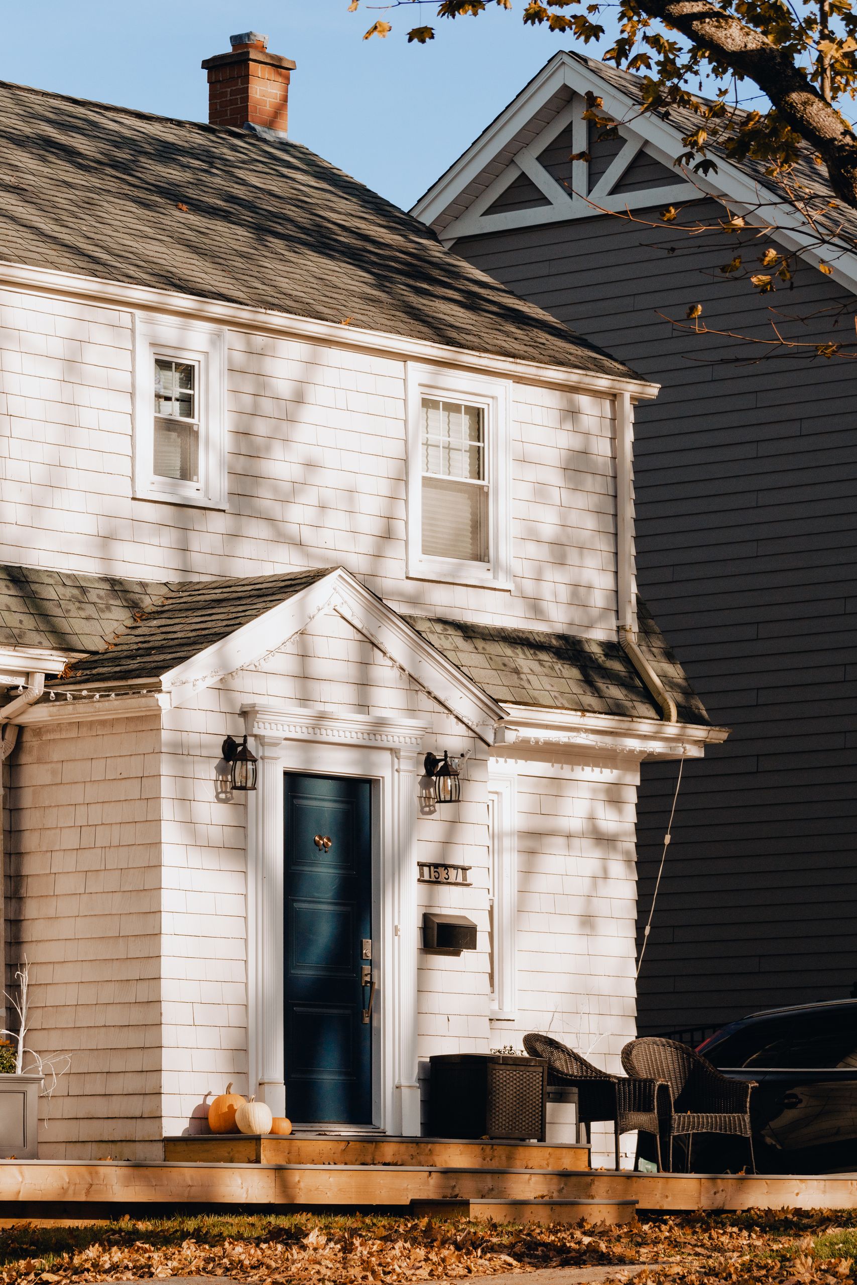 White house facade with autumn decorations and pumpkins on porch in Halifax, Canada.