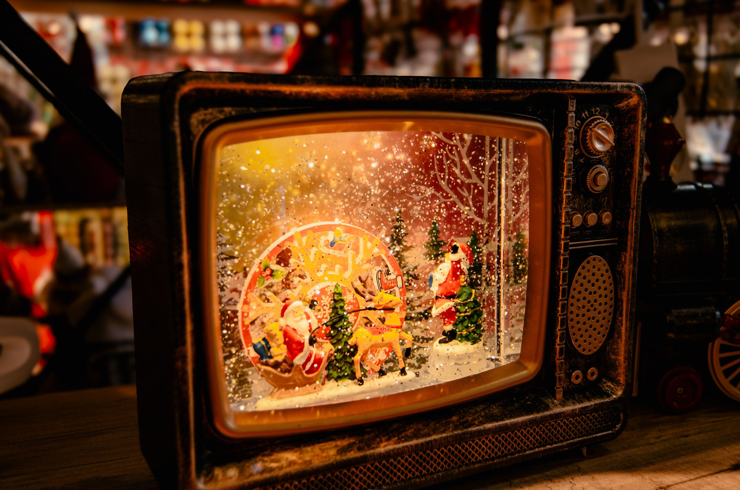 A festive vintage TV showcasing a captivating Christmas scene with snow, Santa, and trees.