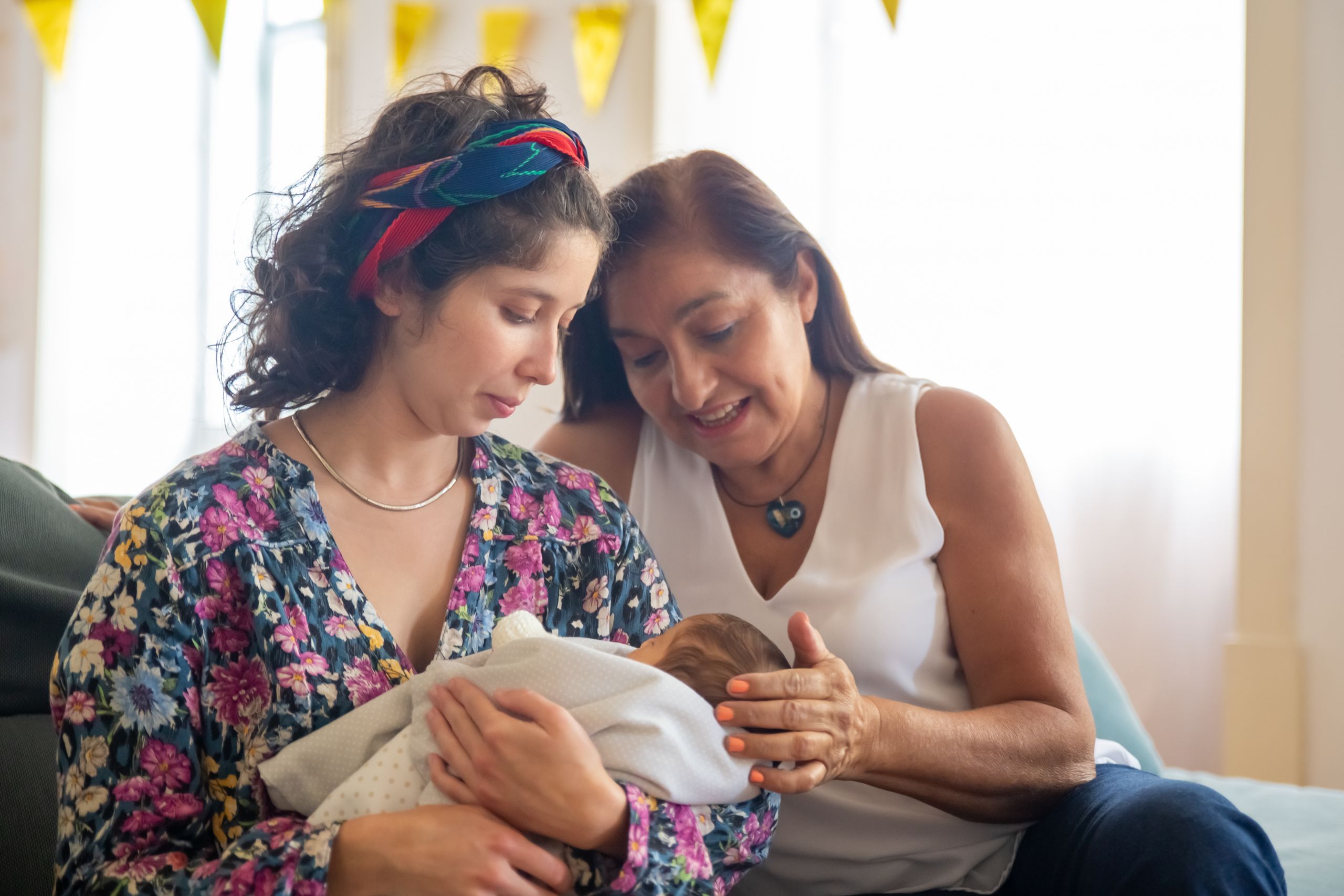 A heartwarming moment of two women embracing a newborn, symbolizing family love.