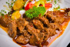 Flavorful beef stew served with vegetables, garnished with parsley.