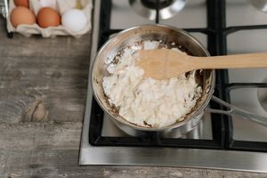 Scrambled eggs with wooden spatula on a stove. Perfect for breakfast inspiration.
